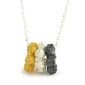 A  peppercorn pendant design, three colorful discs of peppercorns pendant